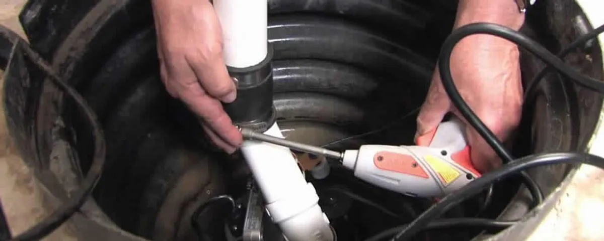 Sump pump installation technician connecting PVC discharge piping in Durham, NC